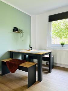 una mesa y un banco en una habitación con ventana en Sali - R3 - Apartmenthaus, WLAN, TV en Remscheid