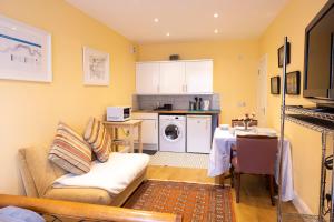 ein Wohnzimmer mit einem Sofa und einem Tisch sowie eine Küche in der Unterkunft London VEGETARIAN Smoke & Pet Free En-suite with EV parking in Stone Grove