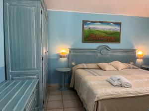 a bedroom with a bed and a painting on the wall at Hotel Baia Cea in Bari Sardo +37 photos