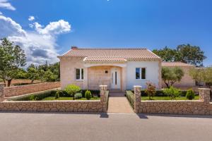 ein Haus mit einem Steinzaun davor in der Unterkunft Apartment Holiday home DoMa, Čilipi near Dubrovnik in Čilipi