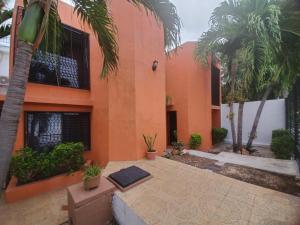 an orange building with a yoga mat in front of it at Casa Las Palmas in Cancún