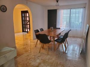 a dining room with a wooden table and chairs at Casa Las Palmas in Cancún