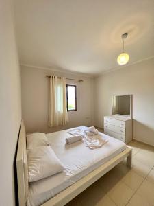 a bedroom with a bed with a dresser and a mirror at Kamberi Hotel & Apartments in Velipojë