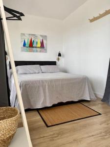 1 dormitorio con 1 cama y suelo de madera en La calma de Tossa, en Girona