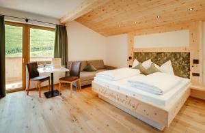 sypialnia z łóżkiem, stołem i krzesłami w obiekcie Edenhauserhof w mieście Innsbruck