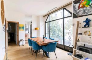 een eetkamer met een houten tafel en blauwe stoelen bij Appartement luxe "La providence" , plein centre in Vichy