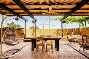 a patio with a table and chairs and a swing at jabotinsky 37 in Zikhron Ya‘aqov
