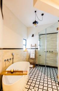 a bathroom with a tub and a glass shower at jabotinsky 37 in Zikhron Ya'akov