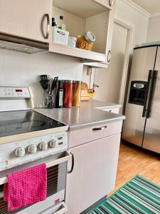 a kitchen with a stove and a refrigerator at Unik Jugend leilighet i sentrum in Ålesund
