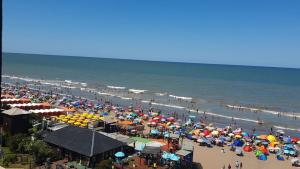 a crowd of people on a beach with umbrellas at Neco Boutique Hotel in San Bernardo