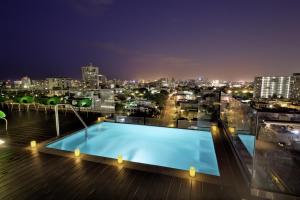 ein Schwimmbad auf dem Dach eines Gebäudes in der Nacht in der Unterkunft Ciqala Luxury Suites - San Juan in San Juan