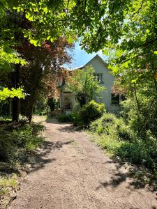 een onverharde weg voor een wit huis bij Les jardins de l'Hermitage in Cellettes