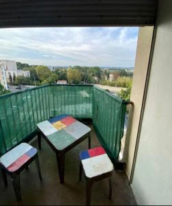 Un balcón con dos mesas y dos taburetes. en T2 Parc Belvédère en Montpellier