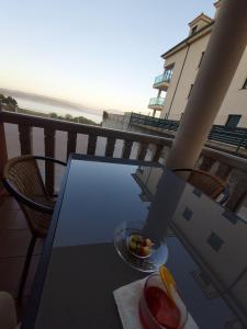 un plato de fruta en una mesa de cristal en un balcón en Apartamento Capricho Finisterre Playa en Finisterre