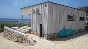 a building with a blue object next to a wall at BUQEZ ECO RESORT - Beach Villas 2 and 8 - Seaview, new wifi! in Drage
