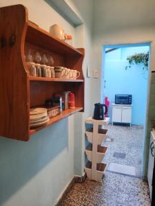 kuchnia z półką z talerzami i patelniami w obiekcie Kela w BuenosAires