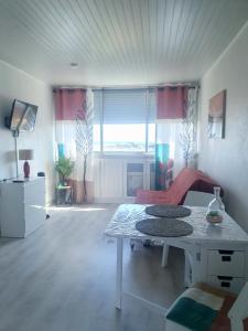 a living room with a table and a large window at Coquet studio au centre port du Cap d'Agde in Cap d'Agde