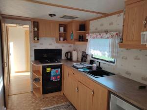 a kitchen with a stove and a counter top at DOMEK NAD JEZIOREM in Żywki