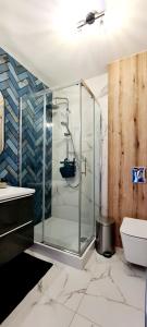 a glass shower in a bathroom with a toilet at Zalamo in Kąty Rybackie