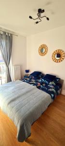 a bedroom with a large bed with a blue comforter at Zalamo in Kąty Rybackie