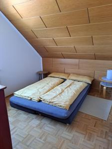 Cama en habitación con techo de madera en Ferien am Wieter in Northeim!, en Northeim