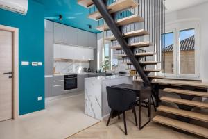 a kitchen with blue ceilings and a spiral staircase at Apartments Madeleine in Rijeka