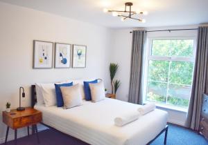 Un dormitorio con una gran cama blanca y una ventana en City Center Apartments FREE PARKING, en Liverpool