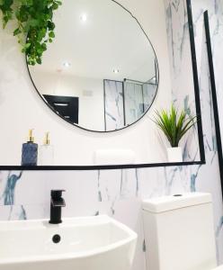 a bathroom with a white sink and a mirror at City Center Apartments FREE PARKING in Liverpool