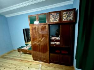a large wooden cabinet in a room with a table at Mishas Haus in Sighnaghi