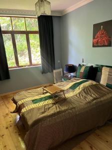 1 dormitorio con 1 cama grande y 1 mesa en Mishas Haus, en Signagi