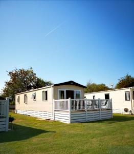 a couple of mobile homes in a yard at Lake Escape - Hoburne Cotswolds in South Cerney