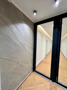 um quarto com uma parede de pedra e uma janela em Kamberi Hotel & Apartments em Velipojë