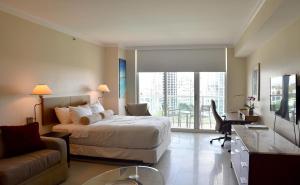 a bedroom with a bed and a desk and a couch at Amazing Studio - Walking Distance To Cocowalk in Miami