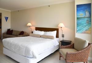 a bedroom with a large white bed and a chair at Amazing Studio - Walking Distance To Cocowalk in Miami +19 photos