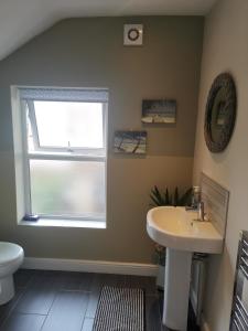 a bathroom with a sink and a window at NEW Derby Pride Park Arena Moorways 4 bedrooms 7 beds -Spacious contractors or group -FREE PARKING in Derby