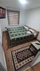 a bedroom with a bed and two rugs on the floor at Glossy private apartment in Sarajevo