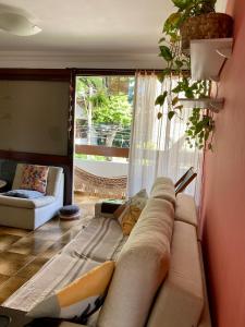 a living room with a couch in front of a window at Suíte em Luna & Line in Salvador