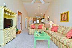 a living room with two couches and a table at Lakefront and 1 Block to Beach! Walk to Main St in Myrtle Beach