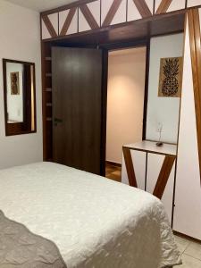 a bedroom with a bed and a wooden door at Suíte em Luna & Line in Salvador