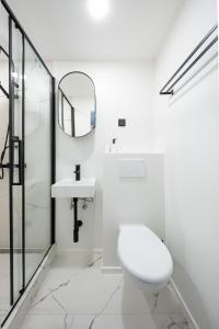 Baño blanco con aseo y lavamanos en Tallinn Oasis Studios by RevalHome, en Tallin