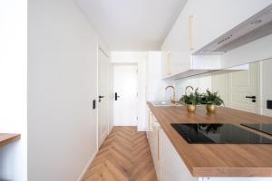 cocina con armarios blancos y encimera de madera en Tallinn Oasis Studios by RevalHome, en Tallin
