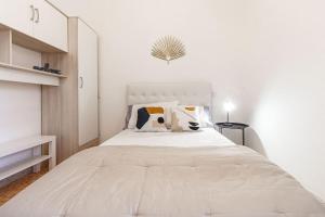 um quarto branco com uma grande cama branca com almofadas em Elizabeth Guest House em Arzachena