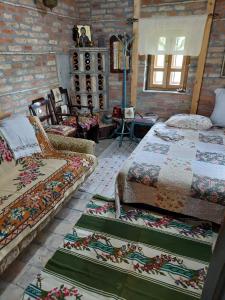a room with two beds and a couch in it at Imanje sa bazenom in Obrenovac