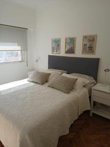 1 cama blanca grande en un dormitorio con ventana en Moderno Depto Pleno Centro en Rosario