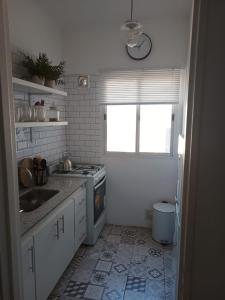 uma cozinha com um lavatório, um fogão e uma janela em Moderno Depto Pleno Centro em Rosário