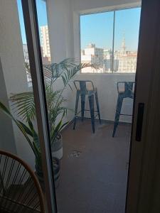 a balcony with a table and chairs and a plant at Moderno Depto Pleno Centro in Rosario