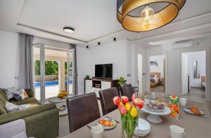 a living room with a couch and a table with flowers at Apartment Holiday home DoMa, Čilipi near Dubrovnik in Čilipi