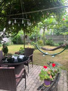 a patio with a hammock and a table and chairs at House of greenery in Kutaisi