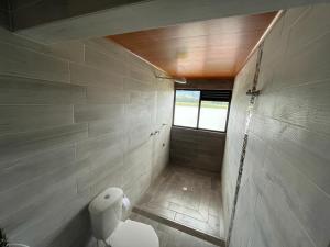 a small bathroom with a toilet and a window at Hotel Villa Blanca Guatavita in Guatavita