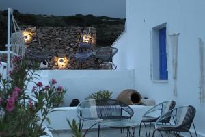 a table and chairs on a balcony with lights at Cycladic Villa in Amorgos Island (Maison Shiro) in Arkesíni
